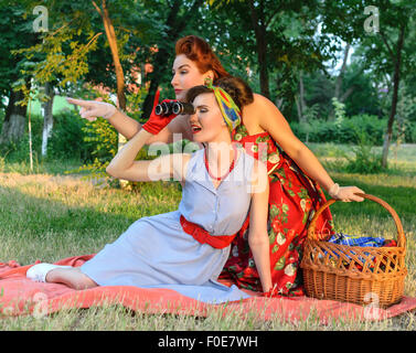 zwei Spion Mädchen verstecken Gesicht hinter dem Buch Pin-up- Stockfoto