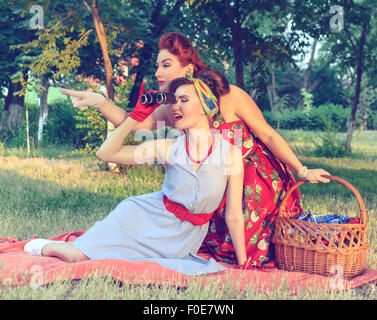 zwei Spion Mädchen verstecken Gesicht hinter dem Buch Pin-up- Stockfoto