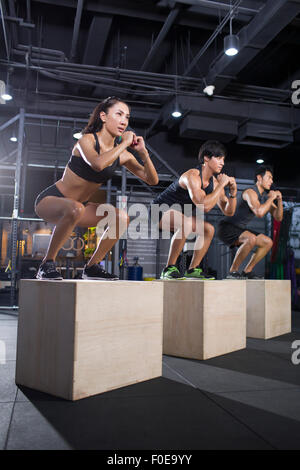 Junge Sportler tun Feld springen in Crossfit gym Stockfoto