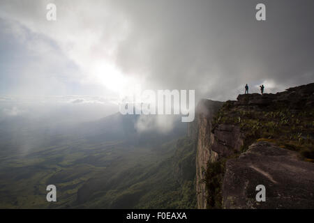 Zwei Personen Fotografieren an der Spitze des Mount Roraima in den Wolken. Die Aussicht ist atemberaubend auf die Gran Sabana. Venezuela-2015. Stockfoto