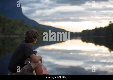 Mann, Blick auf den Sonnenuntergang am Fluss Gauja. Canaima-Nationalpark. Bundesstaat Bolivar, Venezuela 2015 Stockfoto