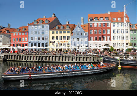 Kanal tour Boot drehen um in überfüllten Nyhavn an einem warmen und sonnigen Sommer Tag voller Touristen und Besucher auch auf der Wharf. Geführte Canal Cruise. Stockfoto