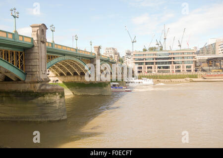 Ein Boot mit Sightseeing-Touren fährt unter der Southwark Bridge in London. Stockfoto