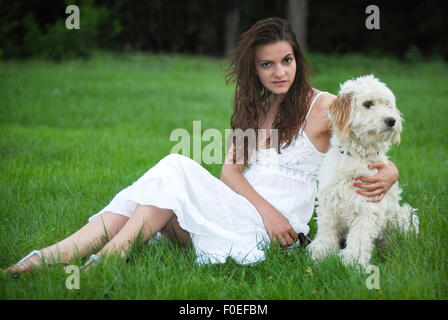 Mädchen mit Hund Gras sitzen Stockfoto