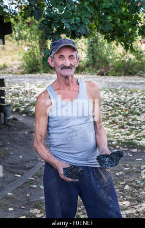 Eine rumänische Köhler hält Klumpen Kohle in Deutsch-Weißkirch, Siebenbürgen, Rumänien, Osteuropa Stockfoto