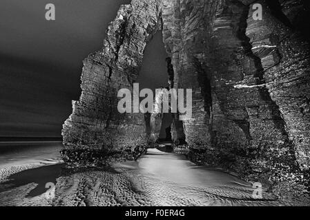 Spanien, Galicien: Felsbogen des Doms Strand bei Nacht als schwarz-weiß-version Stockfoto