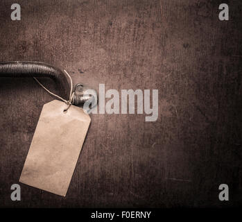 Close up of big old brown suitcase. Detail of blank luggage tag and handle with copy space on the side. The bag is well worn and weathered. Stockfoto
