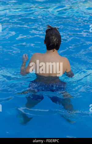 Junger Mann Stand-up in einem Schwimmbad Stockfoto