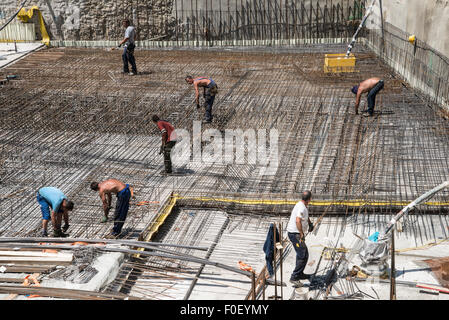 Keller bau Engineering mit einer Gruppe von Männern die Platzierung Stahl Betonstahl - Stangen vor konkreten gewälzt und platziert Stockfoto