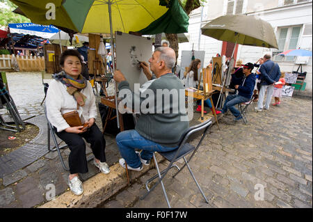 PARIS, Frankreich - 27. Juli 2015: Ein Maler ist ein Porträt der Tourist am Place du Tertre in Montmartre, einer der am meisten f Malerei Stockfoto