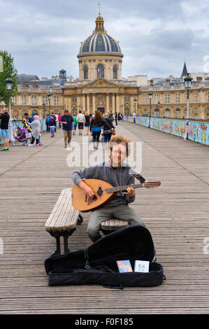 PARIS, Frankreich - 27. Juli 2015: Ein Musiker ist auf "Liebe sperrt Brücke" mit der Akademie der bildenden Künste auf die staatlich Gitarrenspiel Stockfoto