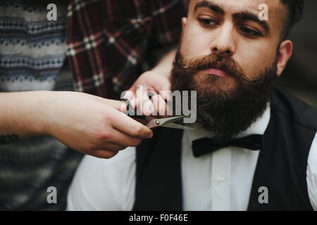 Barbier rasiert ein bärtigen Mannes Stockfoto