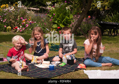 Kinder mit einem Picknick In The Garten auf ein Sommertag Stockfoto