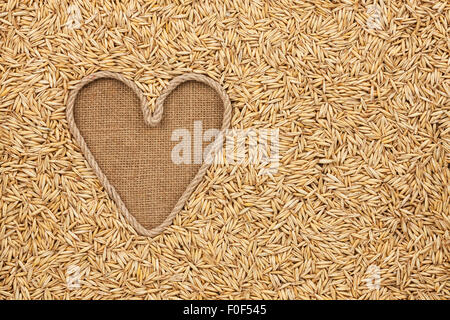 Das symbolische Herz des Seils liegt auf Sackleinen und Hafer Körner, mit Platz für Ihren text Stockfoto