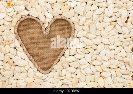Symbolische Herz des Seils liegt auf Sackleinen und Kürbiskerne, mit Platz für Ihren text Stockfoto