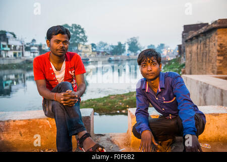 Zwei junge indische Männer entspannen auf einer Brücke über den Fluss Mandakini in Chitrakut, Madhya Pradesh, Indien Stockfoto