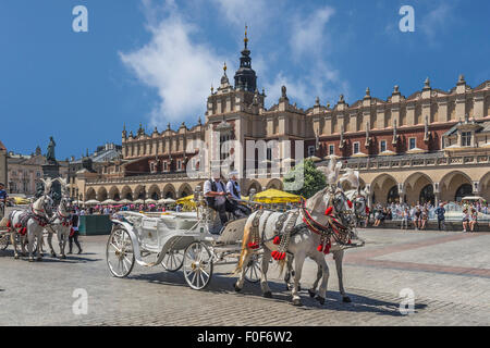 Horse-drawn Wagen erwarten Touristen auf den Krakauer Tuchhallen Main Market Square, Polen, Kleinpolen, Europas Stockfoto