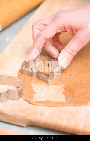 Hand der Frau als Vorbereitung Weihnachten Lebkuchen Kekse backen. Stockfoto