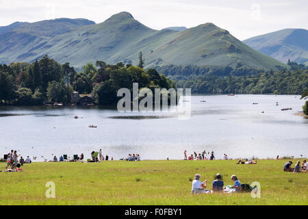Menschen entspannen im Park mit Blick auf Derwentwater und Catbells Fells in der Nähe von Keswick im Lake District, Cumbria, England Stockfoto