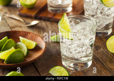 Alkoholische Gin Tonic mit einer Limette garnieren Stockfoto