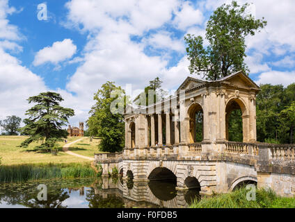 Die palladianische Brücke mit dem gotischen Tempel in der Ferne, Stowe Landscape Gardens, Stowe House, Buckinghamshire, England, UK Stockfoto