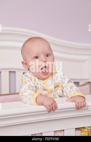 Glückliches Baby in der Krippe stehen Stockfoto