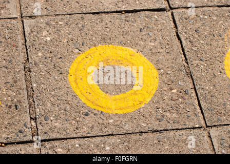 Leuchtend gelbes Schild auf verwitterten Holzbrett mit schwarzem Text