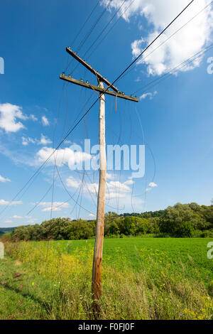 Alten unnötige Holz Elektro Pylon mit gebrochenen Drähten Stockfoto