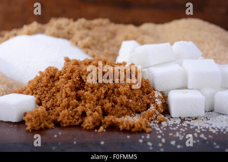 Verschiedene Arten von Zucker, einschließlich weiß, braun, dunkel braun, Demerara, Kaffee Zuckerkristalle und Zuckerwürfel. Stockfoto