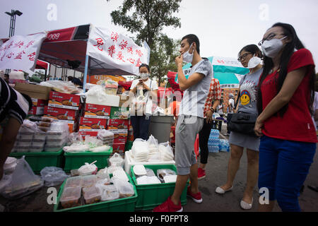 China. 14. August 2015. Menschen gesehen, darauf warten, ihre Versorgung mit Lebensmitteln von Freiwilligen zur Verfügung gestellt bekommen. Eine gewaltige Explosion verursacht mindestens 55 Tote und 750 verletzt bei einer Lagerung von Chemikalien-Anlage in der chinesischen Stadt Tianjin in den frühen Morgenstunden des 13. August. Bildnachweis: Geovien So/Pacific Press/Alamy Live-Nachrichten Stockfoto