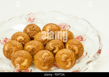 Eine Nahaufnahme der köstlichen, frisch gebacken, goldene braune Kruste Cashew-Muffins auf einem eleganten Glas Tablett serviert. Stockfoto