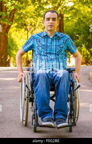 junger Mann im Rollstuhl im Stadtpark Stockfoto