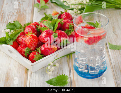 Frische Erdbeeren und Kälte detox Wasser auf Holztisch. Stockfoto