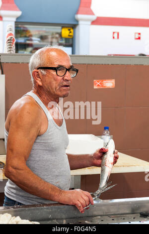 Fischverkäufer Zubereitung von Fisch in der traditionellen Markthalle in Loulé, Algarve, Portugal Stockfoto