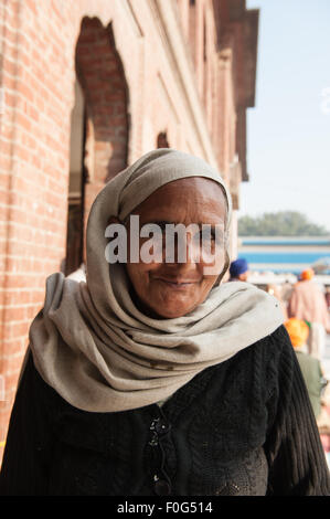 Amritsar, Punjab, Indien. Eine lächelnde Frau Anbeter mit Kopftuch auf den goldenen Tempel Sri Harmandir Sahib. Stockfoto