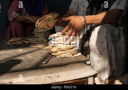 Amritsar, Punjab, Indien. Sri Harmandir Sahib goldenen Tempel. Eine Frau stapelt Roti-Fladen in der freien Küche - Langar - die Zehntausende von Menschen jeden Tag füttert. Stockfoto