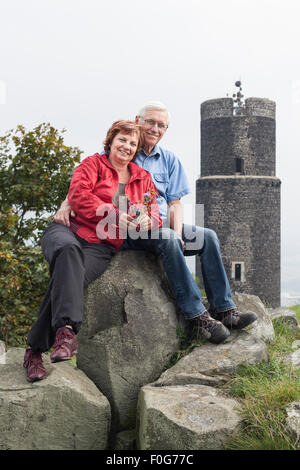 Porträt von senior Brautpaar ruht auf den Felsen neben den Ruinen der Burg Hazmburk in der Tschechischen Republik. Stockfoto