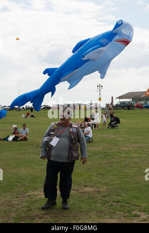 Portsmouth, UK. 15. August 2015. Ein Kite-Handler geht weg von den großen Hai Kite, den er gerade auf dem International Kite Festival geflogen hat. Bildnachweis: MeonStock/Alamy Live-Nachrichten Stockfoto