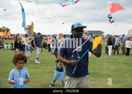 Portsmouth, UK. 15. August 2015. Ein Mann startet eine Reihe von Drachen, wie Kinder auf das internationale Drachenfest zu suchen. Bildnachweis: MeonStock/Alamy Live-Nachrichten Stockfoto