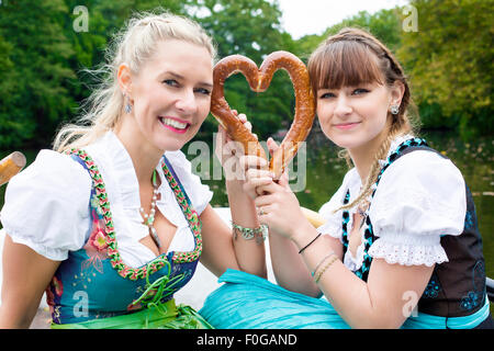 zwei Frauen im Dirndl mit einer Brezel auf ein Ruderboot Stockfoto