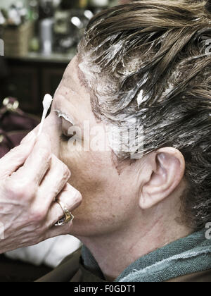 Haar Salon Eigentümer anwenden von Farbe auf weibliche Kunden, Florida, USA Stockfoto