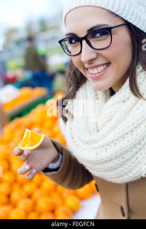 Outdoor Portrait junge schöne Frau, die Früchte auf einem Markt einkaufen. Stockfoto