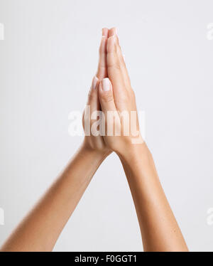 Frau Hände betend vor weißem Hintergrund isoliert Stockfoto