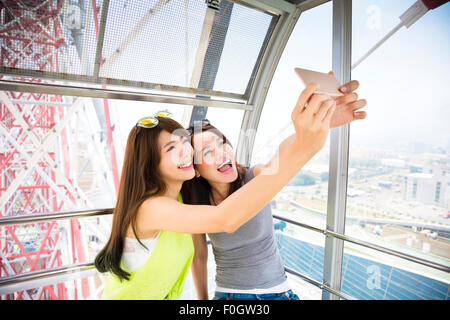 Glückliche Frauen Freundinnen unter einem Selfie im Riesenrad Stockfoto