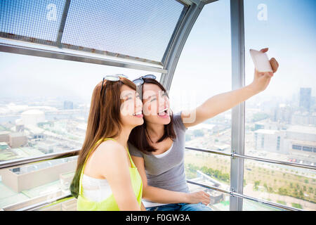 Glückliche Frauen Freundinnen unter einem Selfie im Riesenrad Stockfoto