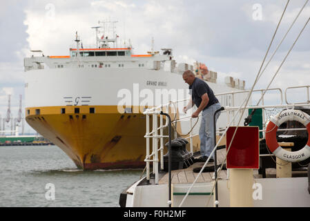 Crew Mitglied binden Seil auf historischen Schiff Shieldhall als ein Autotransporter geht auf Southampton Water UK Stockfoto