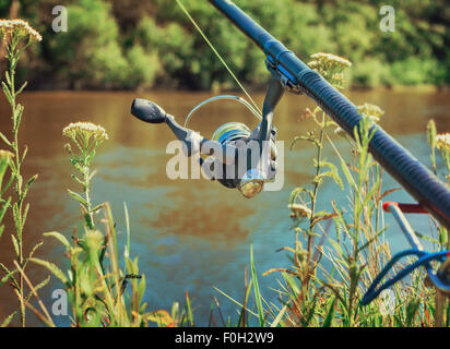 An den Ufern des schönen Flusses oberhalb der Wasser-Feeder installiert - Englisch Angelgerät für den Fang von Fischen mit Stockfoto