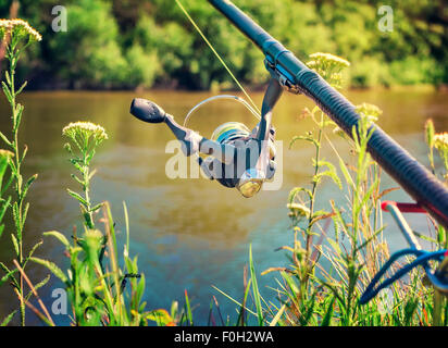 An den Ufern des schönen Flusses oberhalb der Wasser-Feeder installiert - Englisch Angelgerät für den Fang von Fischen mit Stockfoto