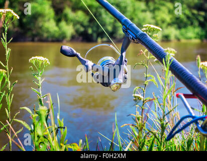 An den Ufern des schönen Flusses oberhalb der Wasser-Feeder installiert - Englisch Angelgerät für den Fang von Fischen mit Stockfoto