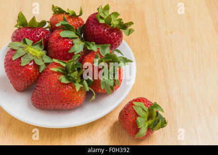 Erdbeeren in weißer Teller auf hölzernen Hintergrund Stockfoto